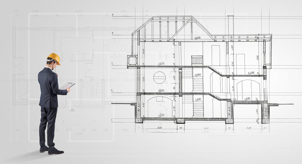 Arhitekt in 2 dimenzionalni načrt hiše.
